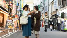 Two persons in the middle of the street talking to each other using a mobile translator app