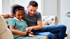 A child setting up a smartwatch with a parent