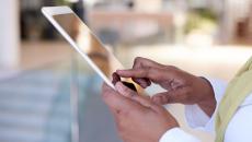 A close up photo of a doctor using a tablet.