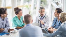 medical providers and business people sit around table