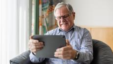 Person sitting in a chair looking at a tablet