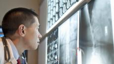 Healthcare provider looking at X-rays on a wall