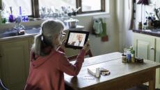 A woman talking with a doctor on her tablet.