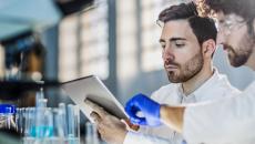 Researchers in a lab using an iPad.