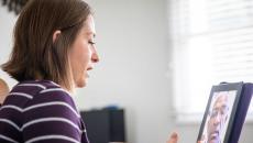 A person talking to a provider through a video chat on a tablet.