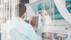 Healthcare researcher looking at a computer while in a lab