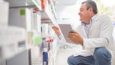 Pharmacist in a pharmacy looking at shelves filled with prescription medication