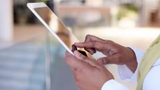 Person on a tablet wearing a yellow scarf and white shirt