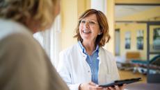 Healthcare provider speaking to a patient while smiling