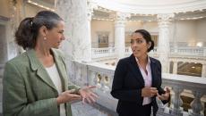 Two people walking through a federal building while talking to each other