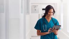 A doctor checking a patient's record on a digital tablet