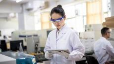 A researcher using a digital tablet in a laboratory.